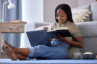 Buy stock photo Student, writing and black woman with book in home living room for elearning, studying and knowledge. Laptop, education and smile of happy female with notebook for notes, information and research.