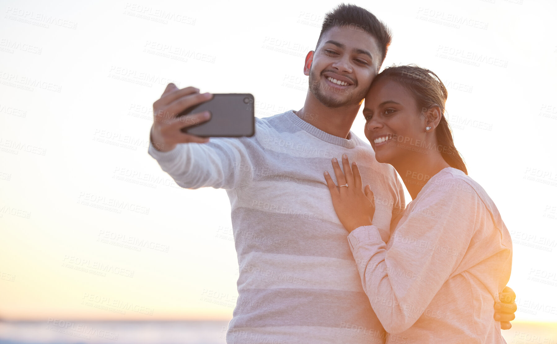 Buy stock photo Selfie, beach and sunset with a couple outdoor together on a romantic date for their honeymoon or anniversary. Photograph, travel or engagement with a young man and woman taking a picture or bonding