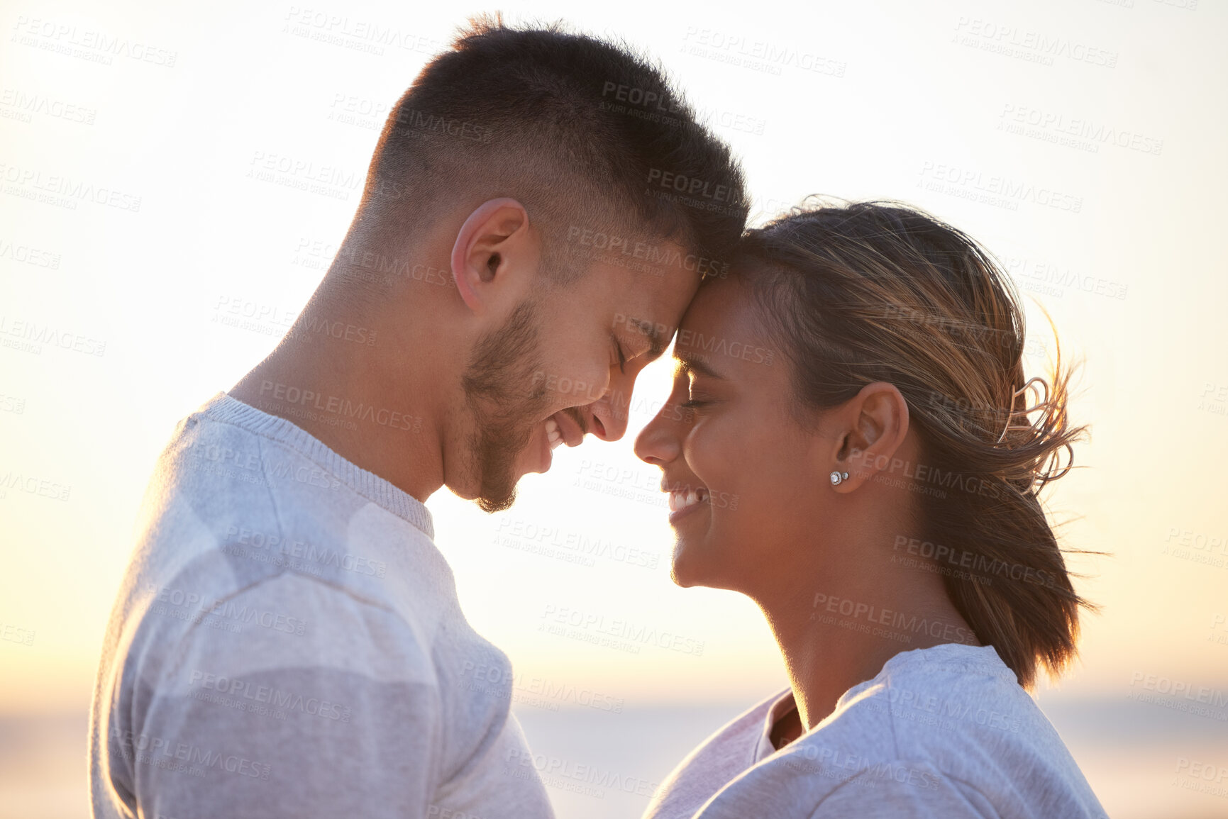 Buy stock photo Couple, sunset forehead touch for love, outdoor beach date and happy holiday together. Man, woman and face of relationship at ocean for freedom, support and relax with trust, peace and smile of care