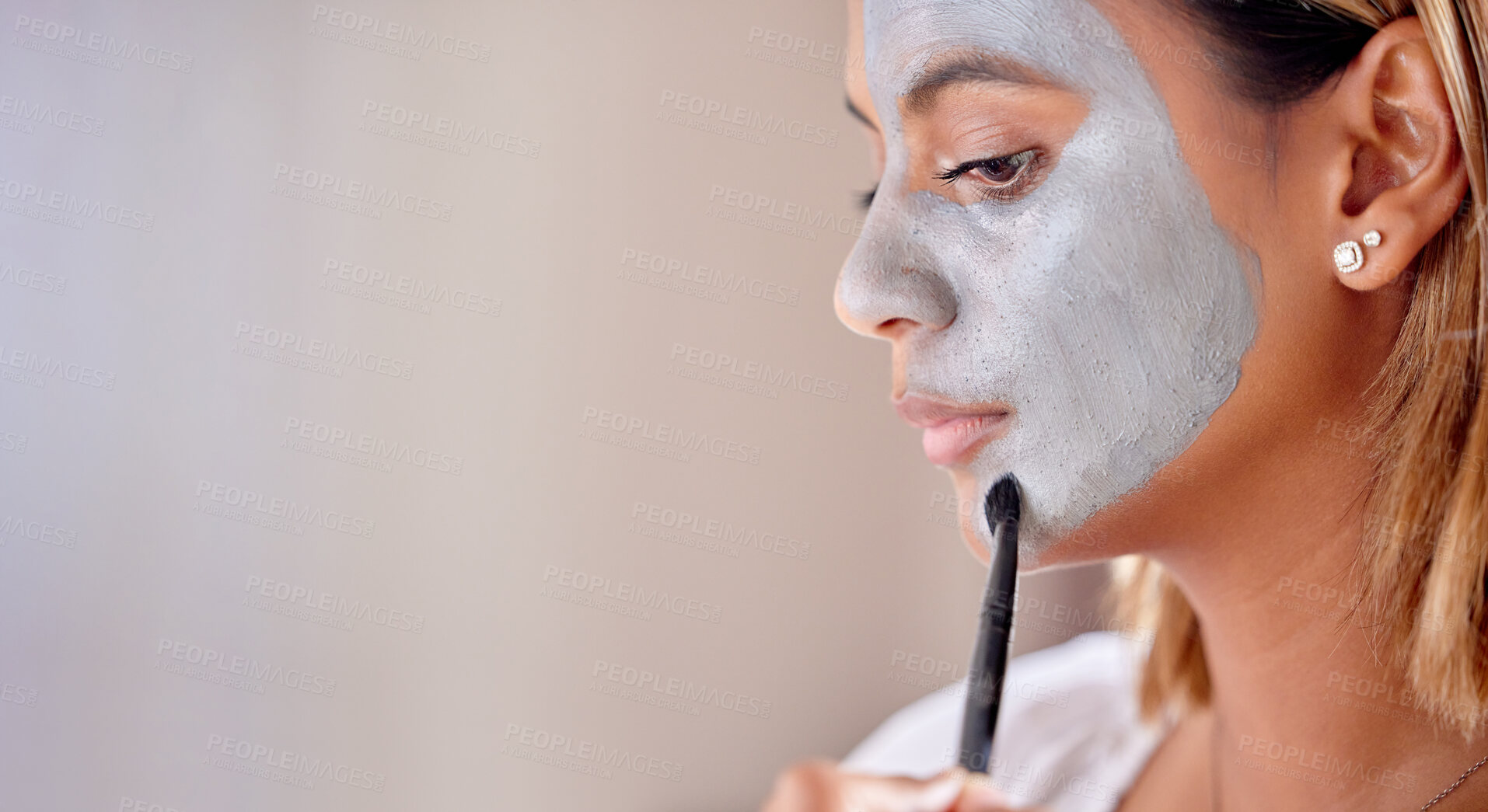 Buy stock photo Woman brush clay makeup on face, mask and detox beauty benefits with mockup wall space. Young female apply charcoal skincare product, facial cosmetics and aesthetic cleaning for dermatology wellness