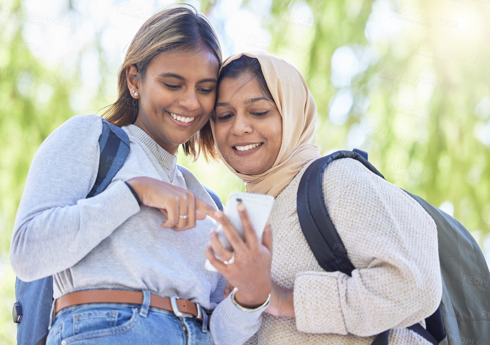 Buy stock photo Low angle, muslim or friends with phone meme, comic joke or comedy on bonding social media, internet or funny blog. Smile, happy or Islamic women on mobile communication technology on school campus