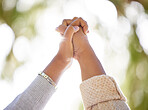 Hand, support or trust with people outdoor together on a nature green background with lens flare in summer. Friends, hope and motivation with women holding hands in unity or solidarity outside