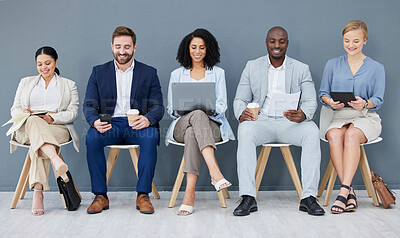 Buy stock photo Business people, diversity and networking in row for recruitment, interview or corporate meeting at office. Group of diverse candidates sitting in waiting room working with technology for team hiring