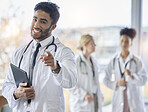 Indian doctor, portrait and happiness of healthcare worker pointing in hospital or clinic. Medical staff, wellness employee and happy smile of a young cardiology intern ready for working with tablet