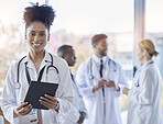 Black woman, doctor portrait and tablet with medical team in hospital ready for healthcare work. Wellness, health and medic employee in a clinic feeling happiness and success with blurred background