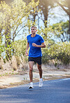 Athlete, running and man exercise in a road outdoors for health, wellness and fitness for energy or cardio strength. Runner, healthy and person training or workout in the street for a challenge