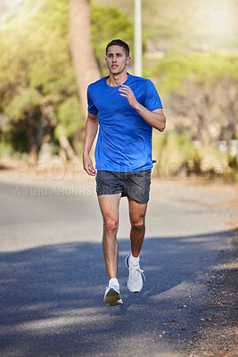 Buy stock photo Fitness, running exercise and man on road for health, wellness and strength outdoors. Sports, training and young male athlete or runner workout, cardio jog or exercising for endurance and energy.