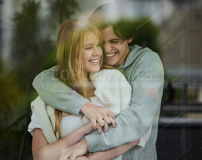 Buy stock photo Couple hug, happiness with smile by window and love with young people, partnership and holding hands with trust. Commitment, relationship and care with happy man and woman are content with joy