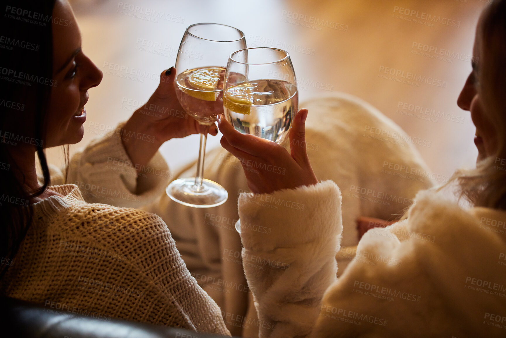 Buy stock photo Women, wine glass and cheers to celebrate together while happy in home to relax, smile and cheers. People or friends toast with alcohol drink in hands for lgbtq, love and care celebration on a couch