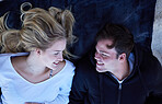 Couple, beach and relax young people on a towel with love, care and bonding outdoor. From above, happy and vacation fun of a woman and man together with a smile on holiday travel by the sea sand