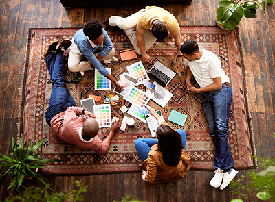 Buy stock photo Collaboration, creative and overhead with a designer team lying on the floor while working on a project. Teamwork, startup or ideas with a group of young people working in advertising or marketing