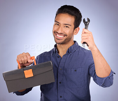 Buy stock photo Portrait, tool and Asian man with box, smile and maintenance with guy against blue studio background. Face, male employee and handyman with happiness, equipment and contractor with service and happy