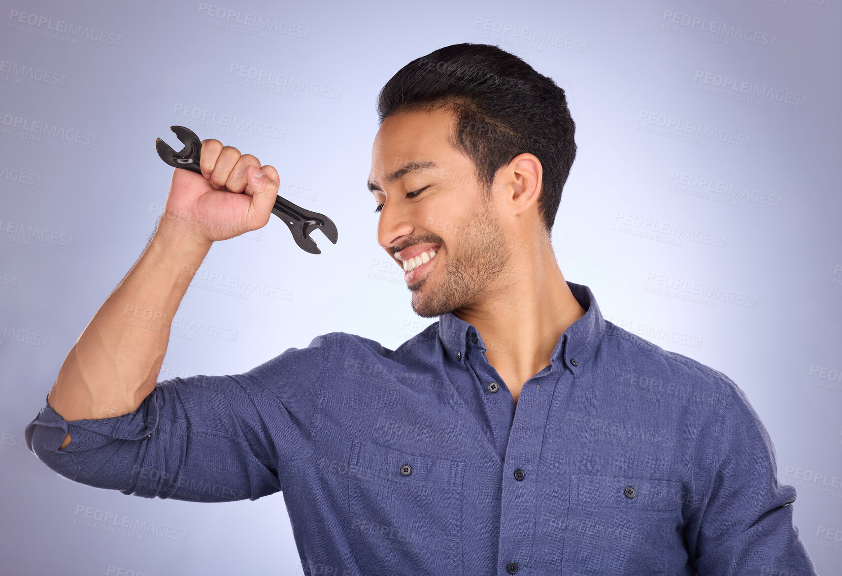 Buy stock photo Man, studio and happy with tools or spanner for handyman, maintenance or repair work. Smile of Asian model person flex strong muscle on purple background for engineer, mechanic or technician job