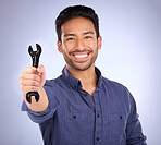 Portrait of man with wrench tool isolated on studio background for repair solution, maintenance or plumbing. Professional worker, asian person or happy plumber hand with mechanic gear for job success