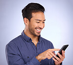 Business asian man, phone and smile for social media, communication or texting against studio background. Happy male smiling on smartphone in networking for chatting, browsing or mobile app on mockup