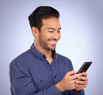 Buy stock photo Business asian man, phone and smile for social media, communication or texting against studio background. Happy male smiling on mobile smartphone in networking for chatting, browsing or app on mockup