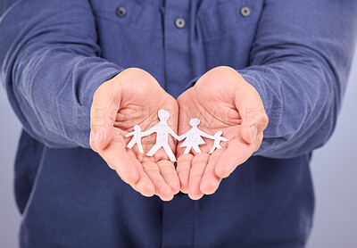 Buy stock photo Showing, hands and man with paper family isolated on a purple background in a studio. Community, insurance and love for group of people, together and collective relationships in a palm on a backdrop