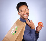 Man in portrait, happy and recycling paper bag with tomato and sustainable shopping on studio background. Eco friendly, vegetable and climate change awareness in retail, sustainability and health