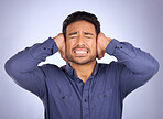 Stress, noise and man closing his ears in studio isolated on a gray background. Loud, mental health and upset, angry or mad business person with headache, depression or anxiety from noisy sound.