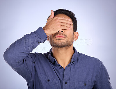 Buy stock photo Hand, face and regret with a man in studio on a gray background feeling disappointed by a mistake. Facepalm, problem and frustrated with a male covering his eyes while annoyed, upset or ashamed