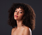 Portrait, makeup and beauty by black woman in studio for glamour, treatment and body care on black background. Face, girl and curly afro model relax with luxury, soft and glowing skin while isolated 