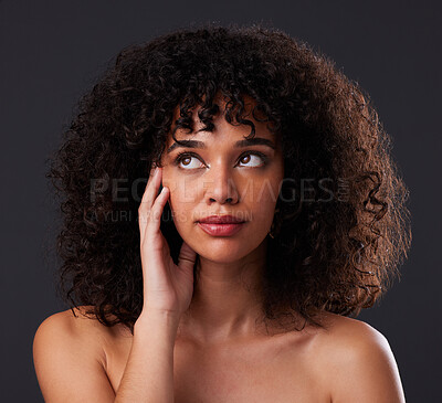 Natural, beauty and black woman in studio for hair, treatment or body care on black background. Face, hand and girl thinking, curly and afro model relax in luxury, soft or glowing skin while isolated