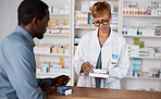 Pharmacist woman, medicine and healthcare with customer while reading information on pills box. Black man with pharmacy, clinic or store worker for pharmaceutical, medical and health counter service