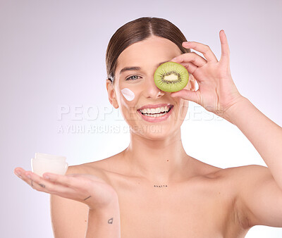 Buy stock photo Woman, face and kiwi with moisturizer for skincare nutrition, cream or healthy diet against gray studio background. Portrait of happy female with fruit and creme for natural organic facial cosmetics