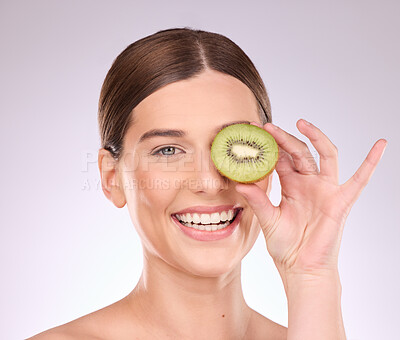 Buy stock photo Woman, face and hand with kiwi for skincare nutrition or healthy diet against gray a studio background. Portrait of happy female smile with fruit for organic facial treatment or natural cosmetics