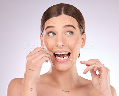 Buy stock photo Flossing, woman and teeth in studio for beauty, healthy dental wellness and skincare on background. Female model, tooth floss and cleaning mouth for fresh breath, oral maintenance or cosmetic results