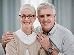 Portrait, love or commitment with a senior couple hugging in the living room of their house together. Smile, space or trust with a happy mature man and woman bonding while enjoying retirement at home