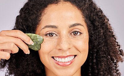 Buy stock photo Face skincare, portrait and black woman with gua sha in studio isolated on a gray background. Dermatology, cosmetics and happy female model with tool, stone or crystal for healthy skin and wellness.