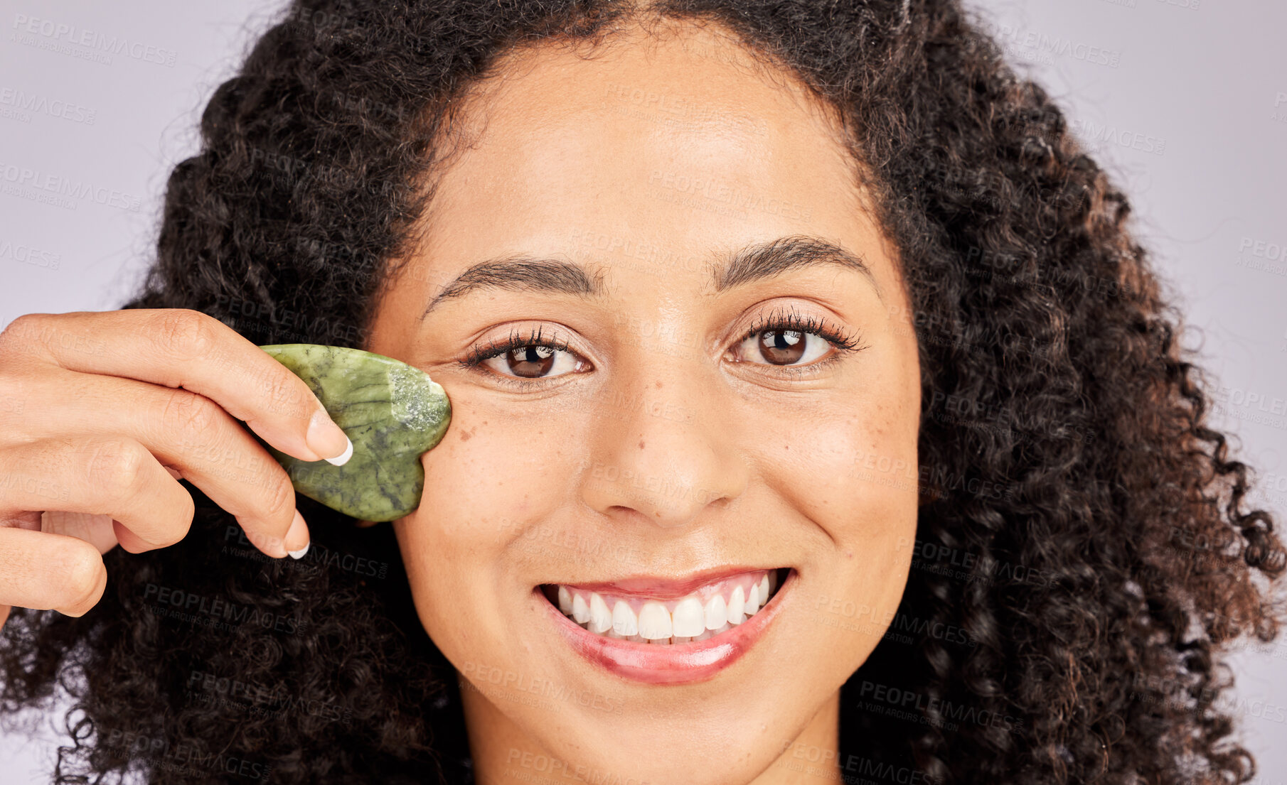 Buy stock photo Face skincare, portrait and black woman with gua sha in studio isolated on a gray background. Dermatology, cosmetics and happy female model with tool, stone or crystal for healthy skin and wellness.