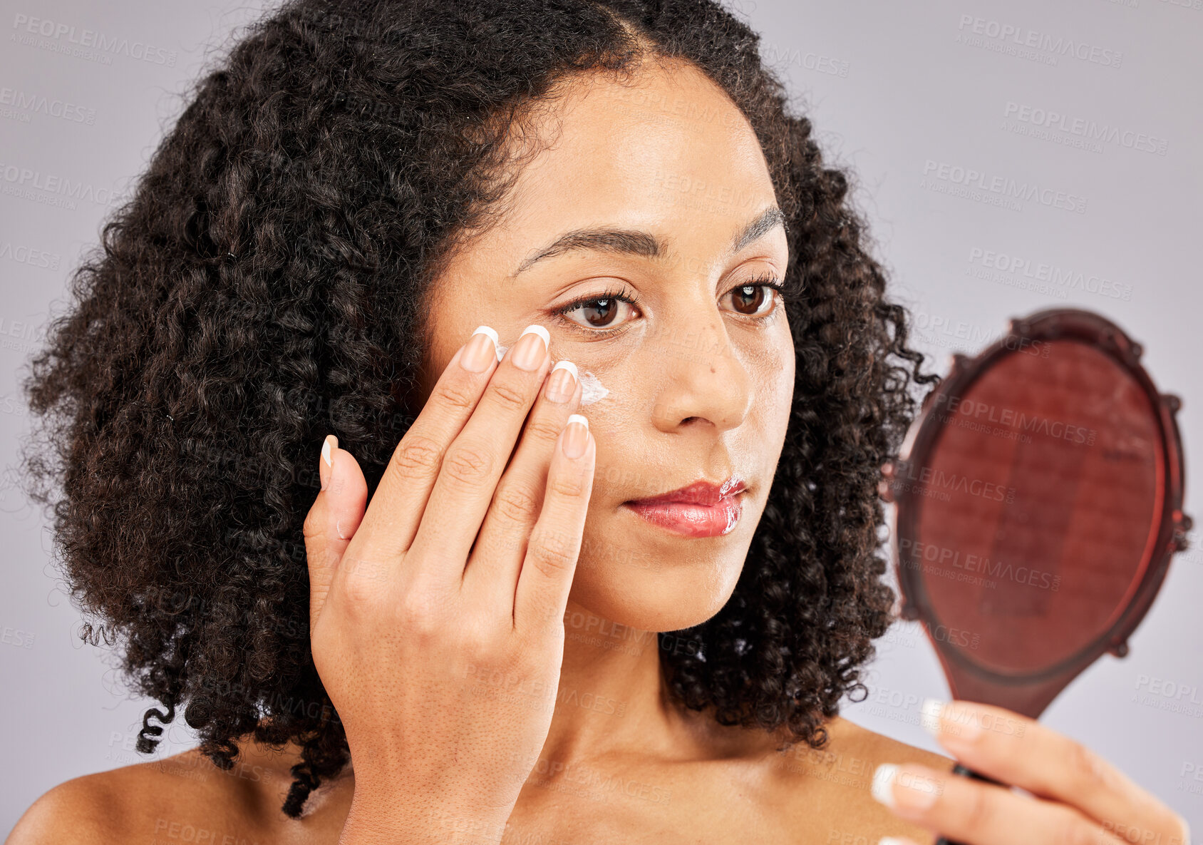Buy stock photo Face, skincare cream and black woman with mirror in studio isolated on a gray background. Dermatology cosmetics, reflection and female model with lotion, creme or moisturizer product for skin health.