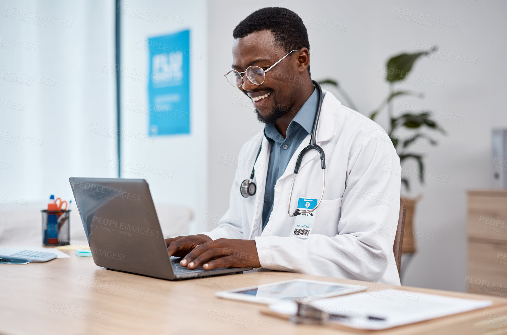 Buy stock photo Black man, doctor and laptop with smile in healthcare for research, medicine or PHD at clinic desk. Happy African American male medical professional smiling, working or typing on computer at hospital