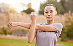 Fitness, portrait and woman stretching arms in nature to get ready for workout, training or exercise. Sports, face and young female athlete stretch and warm up to start exercising, cardio or running.