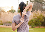 Back, fitness and woman stretching arms in nature to get ready for workout, training or exercise. Sports, health and young female athlete stretch and warm up to start exercising, cardio or running.