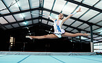 Gymnastics, woman athlete and performance at gym, fitness and leap, legs stretching and in the air with flexibility. Exercise, competition and professional female gymnast with sports and hula hoop 