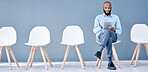 Waiting room, tablet and black man sitting at job opportunity, career application or Human Resources interview. Professional person or worker search online website for hr recruitment or hiring email