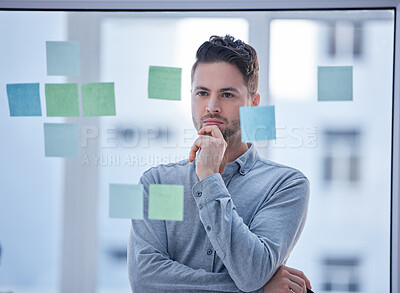 Buy stock photo Creative man, thinking and brainstorming in schedule planning glass board for tasks or reminder at office. Male wondering in thought for project plan, idea or sticky note strategy for company startup