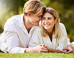 Love, grass and nature with a couple lying together on a field for romance or affection during a date. Spring, park or peace with a young male and female bonding while enjoying a summer picnic