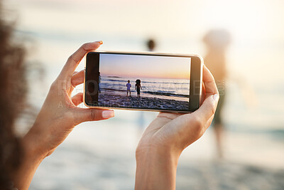 Buy stock photo Phone, photograph and beach with a woman in nature, recording her playing kids by the ocean outdoor. Mobile, family and sunset with a parent taking a picture of her kids on the sand at the sea