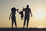 Silhouette, beach and a family with children by the ocean, playing together in nature at sunset from the back. Summer, travel or love with a mother, father and kid having fun while bonding at the sea