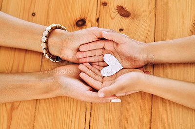 Buy stock photo Hands holding, heart and shape of love by parent and child in support, care and unity together on a table in a home. Top view, family and people in adoption with hope symbol and bonding
