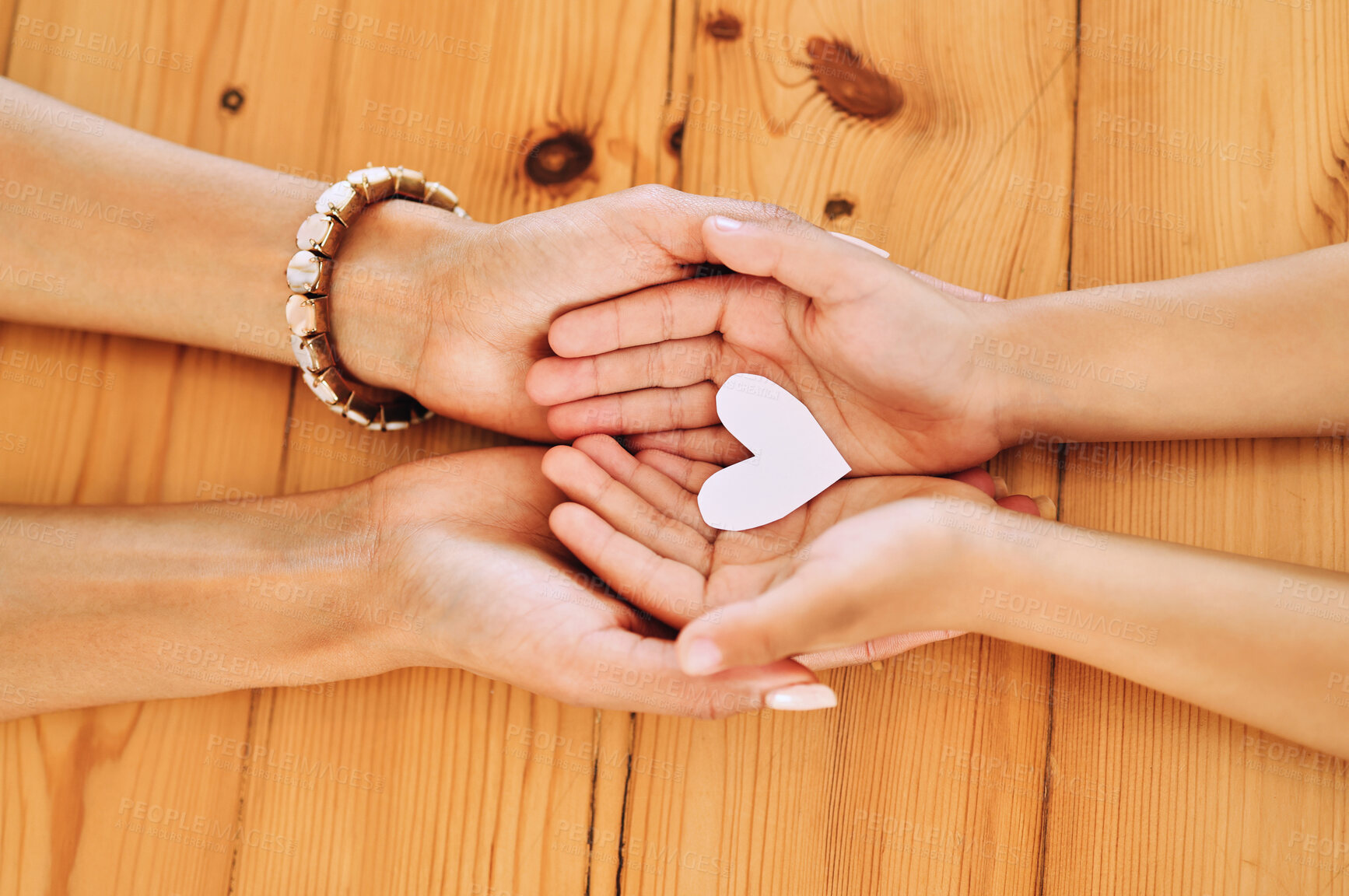 Buy stock photo Hands holding, heart and shape of love by parent and child in support, care and unity together on a table in a home. Top view, family and people in adoption with hope symbol and bonding