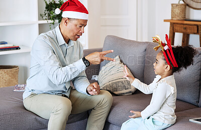 Senior family and kid play Christmas game together for fun, learning and bonding with numbers education. Grandfather or mature man talking and teaching girl child in lounge for thanksgiving holiday