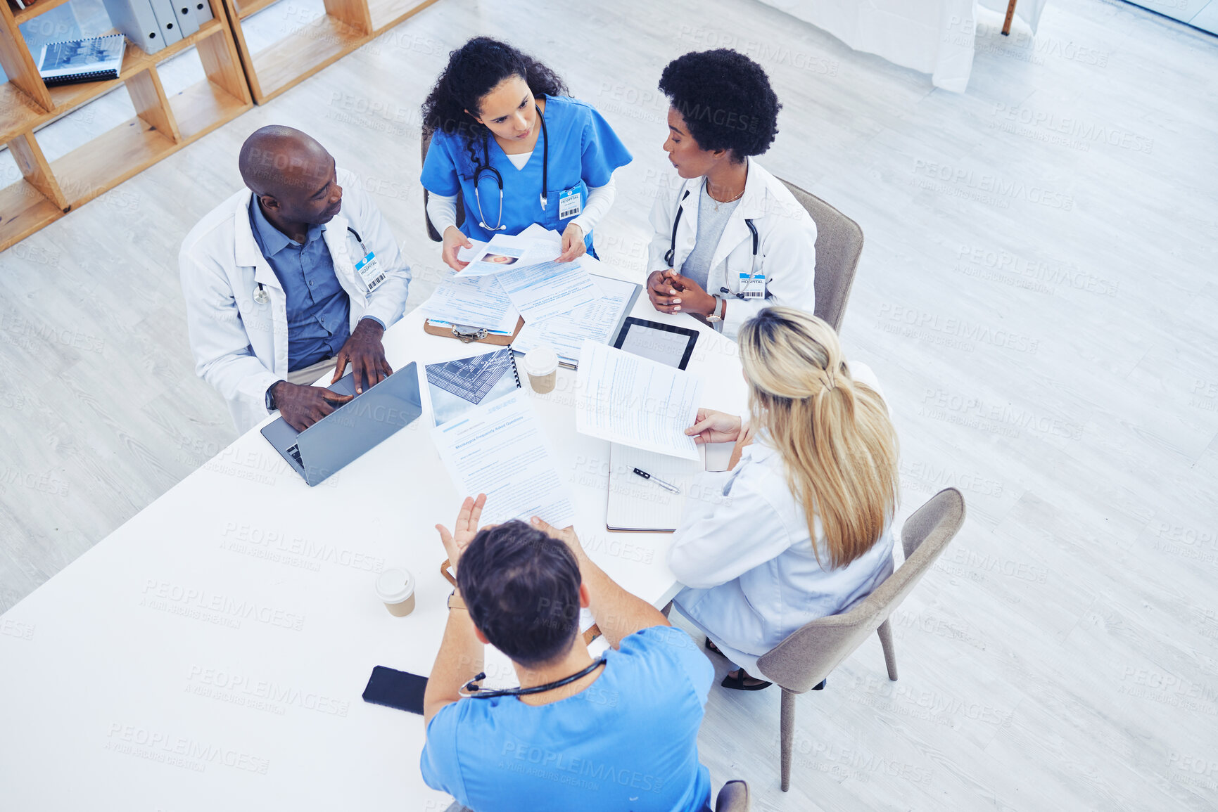 Buy stock photo Above, healthcare and meeting by doctors on laptop for research, planning and innovation at hospital. Doctor, team and health experts brainstorm, problem solving or discussing online project together