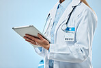 Doctor hands, tablet and medical technology for a hospital or clinic in a studio. Isolated, blue background and healthcare professional with tech data for wellness report on a digital nursing app