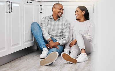 Buy stock photo Love, happy and couple relax on a floor, talking and bonding in their home kitchen with coffee. Marriage, tea and man sitting with woman, laughing and enjoying conversation and relationship indoors