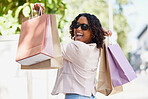 Black woman, portrait and happy with shopping bag in street for discount, sale and sunshine with sunglasses. Young gen z girl, metro and excited with retail, fashion or gift on walk outdoor in city